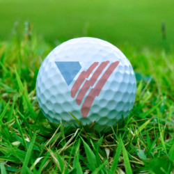 White golf ball sits on green grass with the VOA blue and red "V" logo in the center.