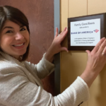 Colleen Matteson, president of Bank of America Rochester holds plaque for a dedicated family room at the Guest House family shelter.