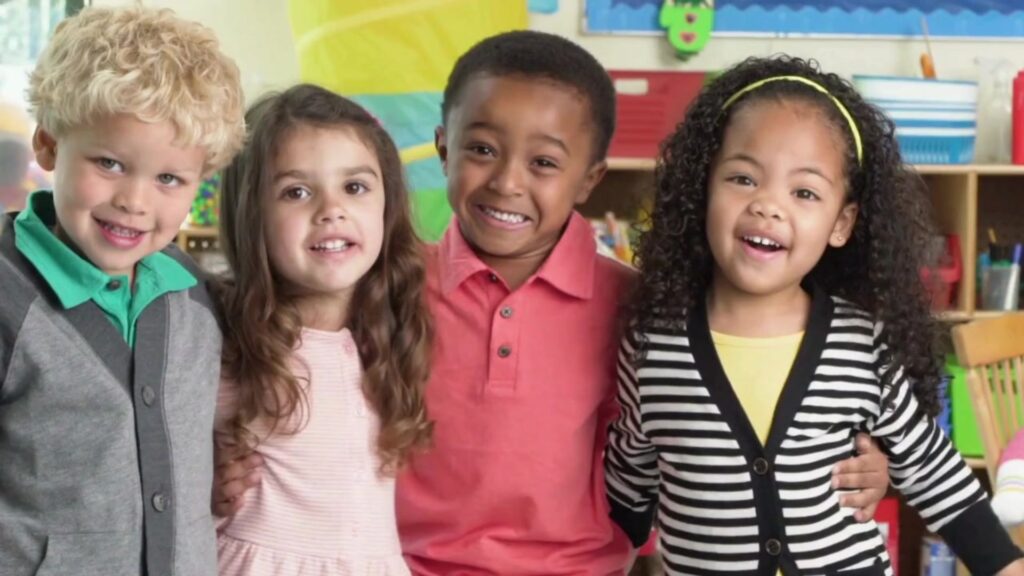 Four preschool age children gleefully smile for a camera.
Caring Gift of Education