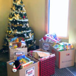 Christmas tree with boxes of donated toys.