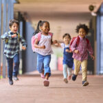 Kids running down a school hallways.