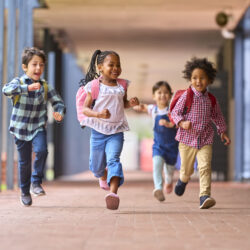 Kids running down a school hallways.