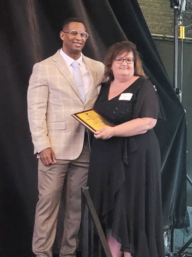 Dr. Junior Dillion with representative from Regional Health Reach accepting award