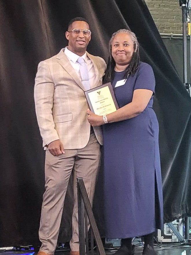 Phyllis Robinson stands with Dr. Junior Dillion to receive an award